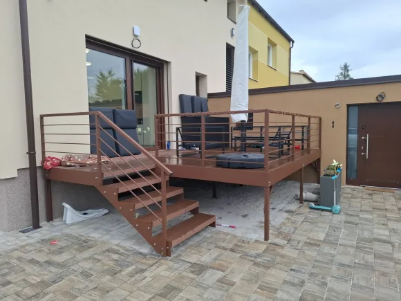 Hnědá terasa s kompozitním schodištěm a tyčovým zábradlím