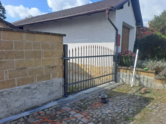 Detail posuvné kované brány s hroty na kolejnici